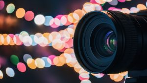 A camera lens positioned against a vibrant,colorful background,ideal for visual marketing and commercial use.