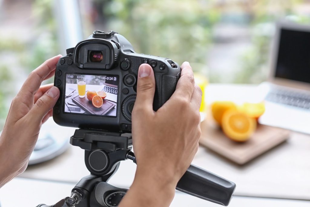 A person capturing a photo of a delicious meal with a camera,ideal for visual marketing and commercial use.