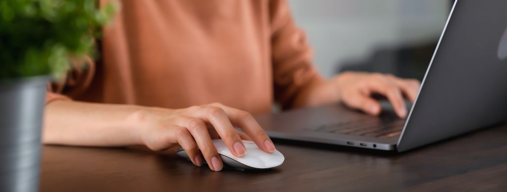 A woman typing on a laptop, engaged in digital marketing and social media activities, with emojis enhancing her work.