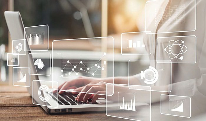 A woman using a laptop with icons on the screen, engaged in marketing automation and lead scoring.