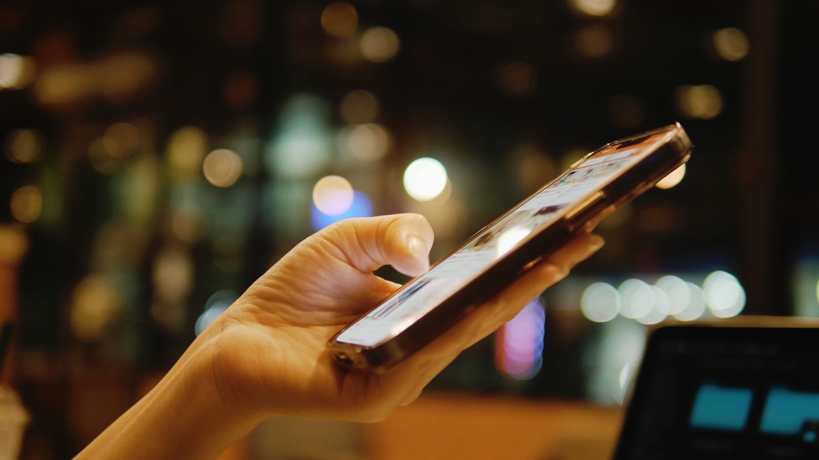 A person’s hand displaying a cell phone, showcasing the device's screen and buttons.